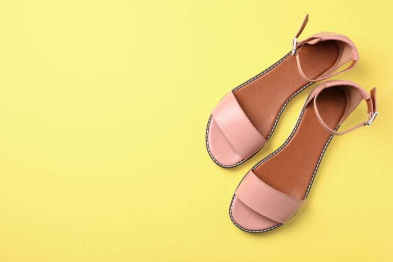 Pair of trendy women's shoes on color background, top view